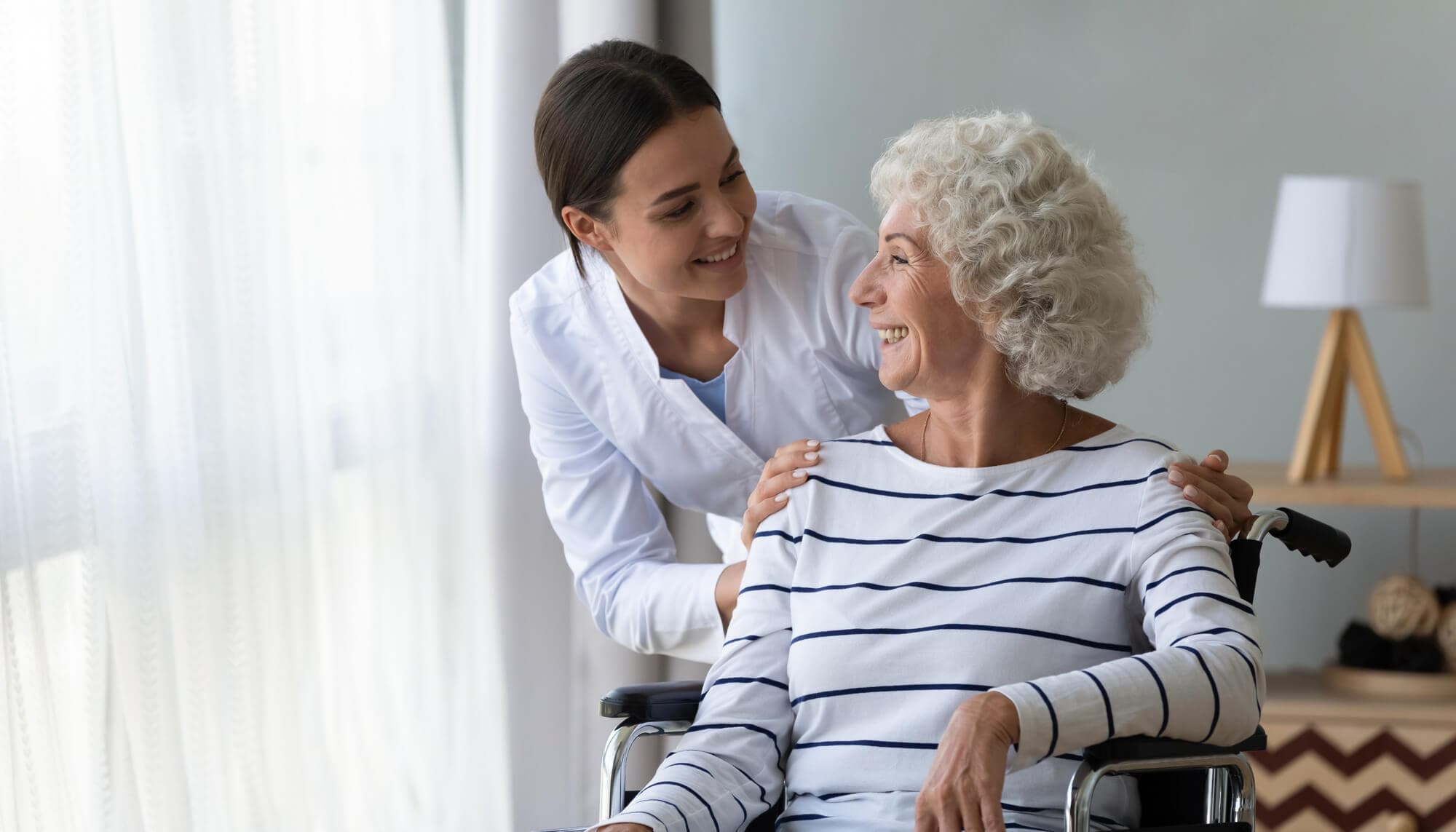 An elderly woman being cared for by a nurse