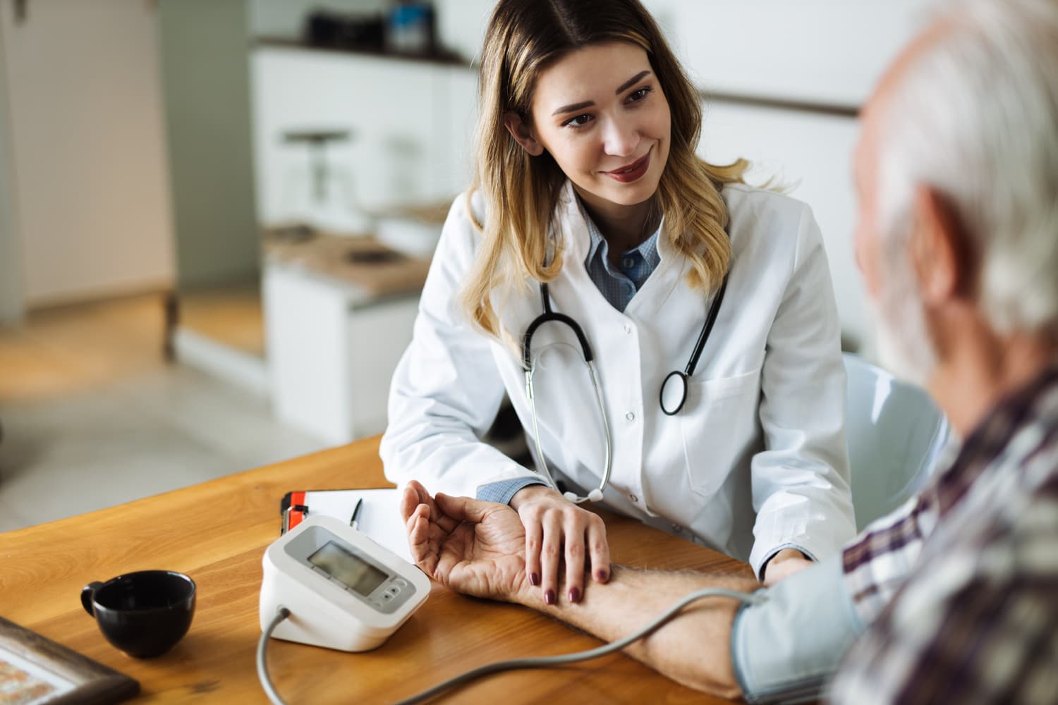 A housecall doctor checking a patient's blood pressure at his NYC home.