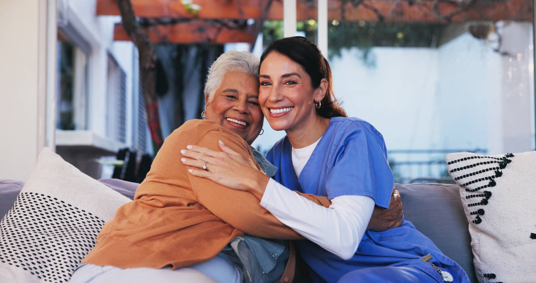A nurse and a patient giving each other a hug