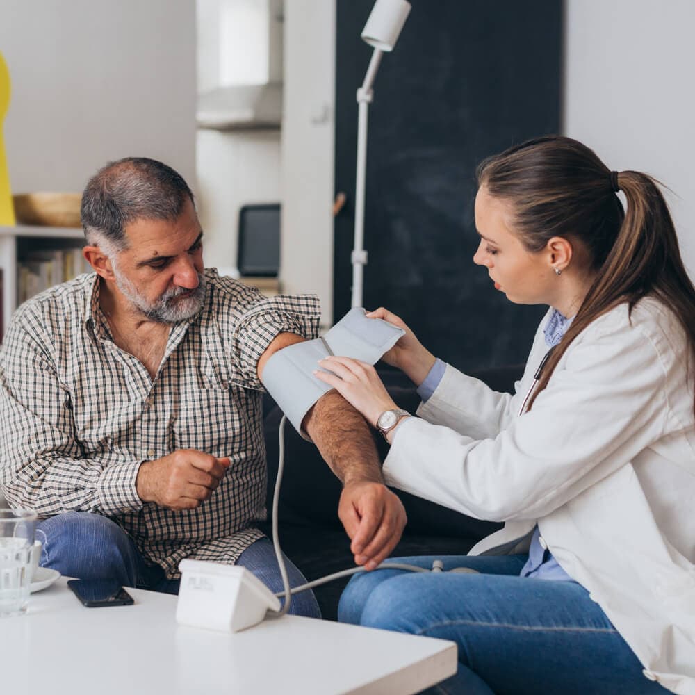 A clinician measuring a patient's blood pressure at home